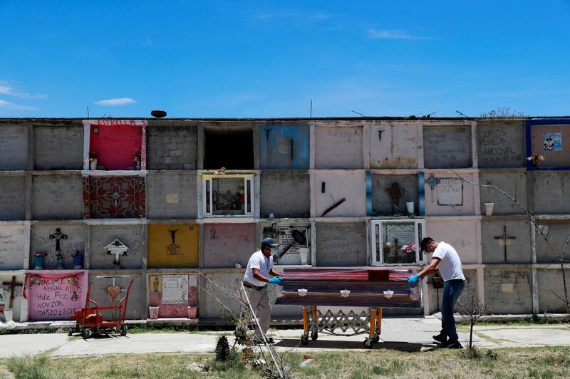 Funeral workers move the coffin of a woman, who died of the coronavirus disease, at the Municipal cemetery in Nezahualcoyotl, State of Mexico, Mexico. Reuters