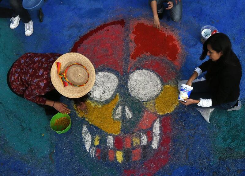 Residents create a sawdust representation of a skull during Day of the Dead festivities in Mexico City, on October 27, 2016. The holiday honours the dead, as friends and families gather in cemeteries to decorate their loved ones’ graves and hold vigils through the night on November 1 and 2. Marco Ugarte / Associated Press