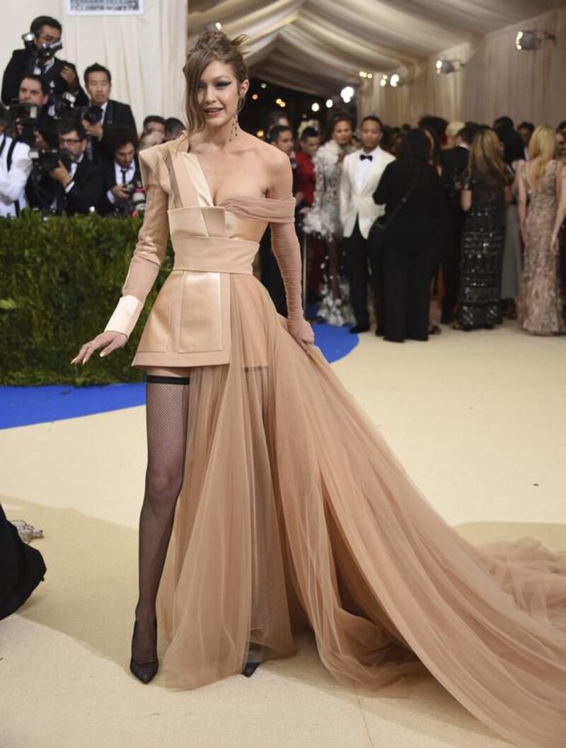 Sans Zayn Malik, Gigi Hadid attends the Met Gala wearing a tulle-adorned dress by Tommy Hilfiger, accessorising with fishnet stockings. Evan Agostini / Invision / AP