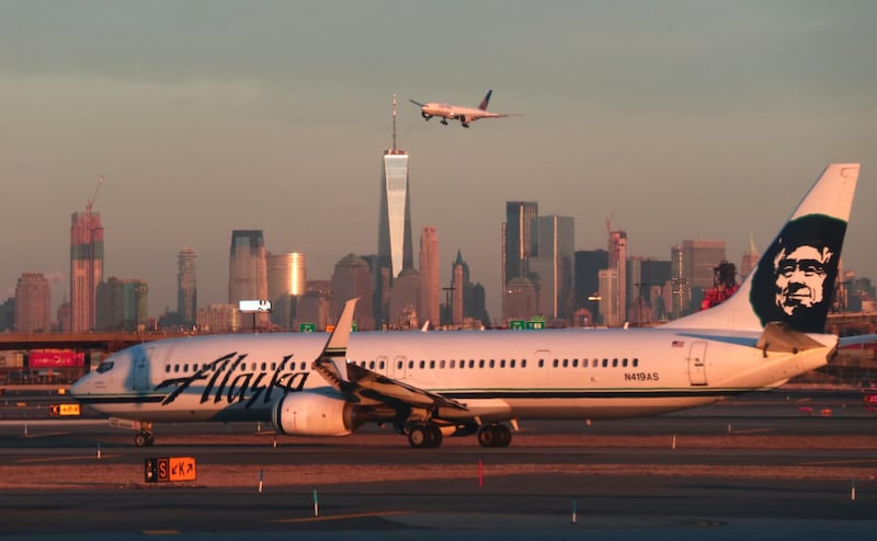 NEWARK, NJ - JANUARY 21: An Alaska Airlines airplane passes by the skyline of lower Manhattan in New York City as it heads to a gate at Newark Liberty Airport on January 21, 2019 in Newark, New Jersey. (Photo by Gary Hershorn/Getty Images)