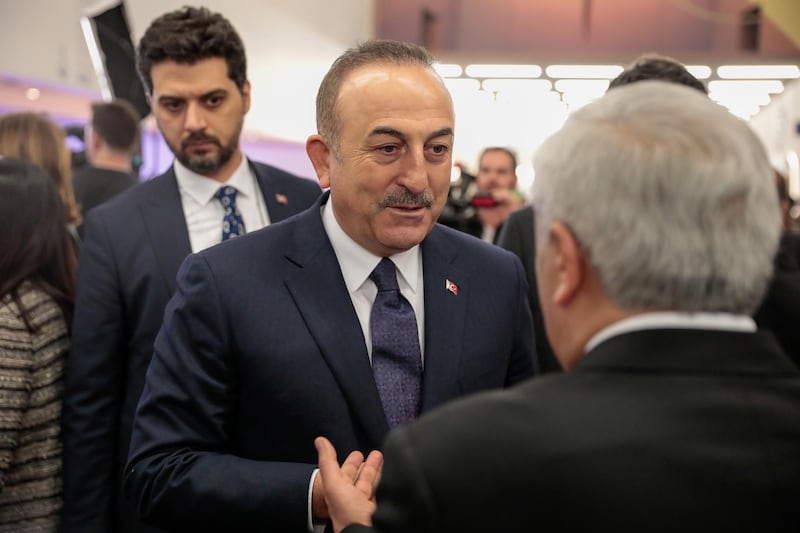 Mevlut Cavusoglu, Turkey's foreign affairs minister, speaks to an attendee between sessions on the opening day of the World Economic Forum (WEF) in Davos, Switzerland, on Tuesday, January 21, 2020. Jason Alden/Bloomberg