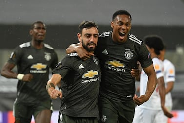 Manchester United's Bruno Fernandes, left celebrates after scoring the opening goal of the game during the Europa League semifinal soccer match between Sevilla and Manchester United in Cologne, Germany, Sunday, Aug. 16, 2020. (Ina Fassbender/Pool Via AP)