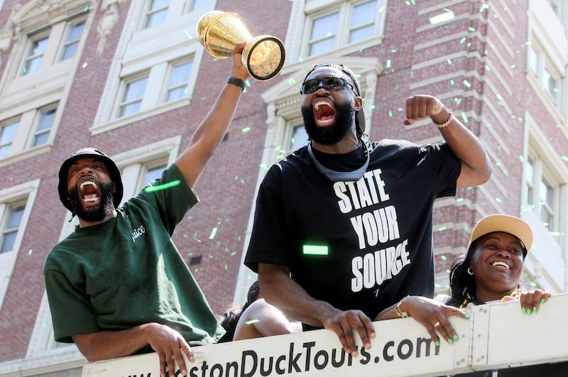 Jaylen Brown holds the trophy during a parade to celebrate the Boston Celtics' 18th NBA Championship in Boston, Massachusetts. Reuters