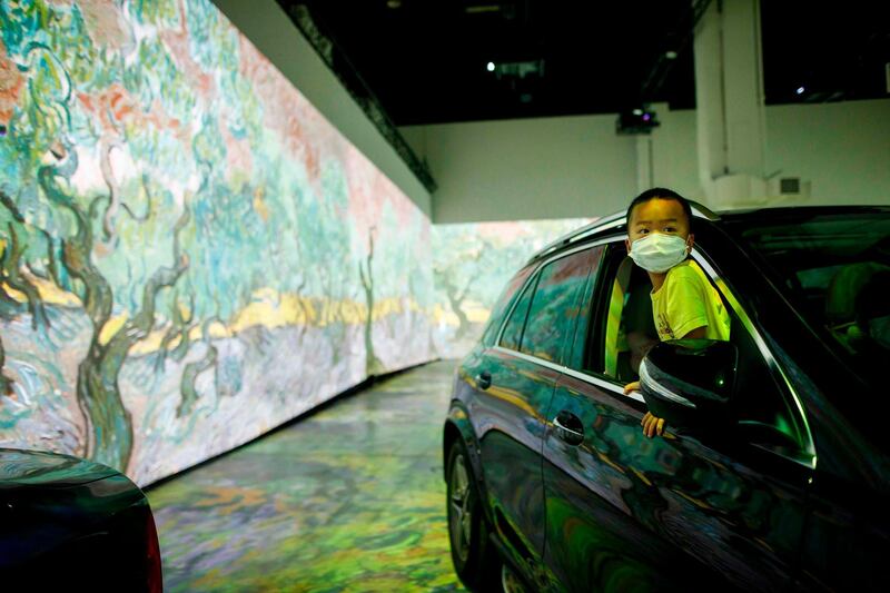 Tyler Tsang, 4, peeks his head out of the car during the show. AFP