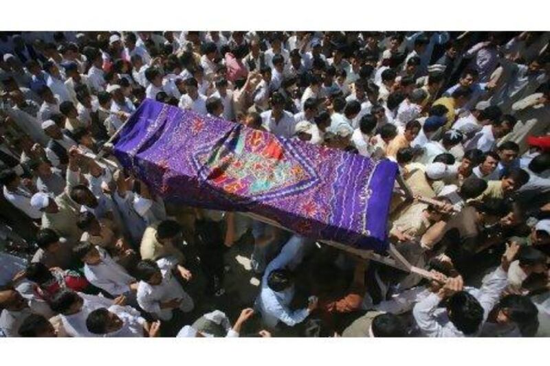 Mourners carry the coffin of a man was killed in a shootout by unidentified gunmen a day earlier, for his burial in Quetta yesterday. Gunmen opened fire on a bus in Baluchistan in a suspected sectarian attack on Tuesday, killing at least 26 Shiite Muslim pilgrims travelling to Iran, police said. Naseer Ahmed / Reuters