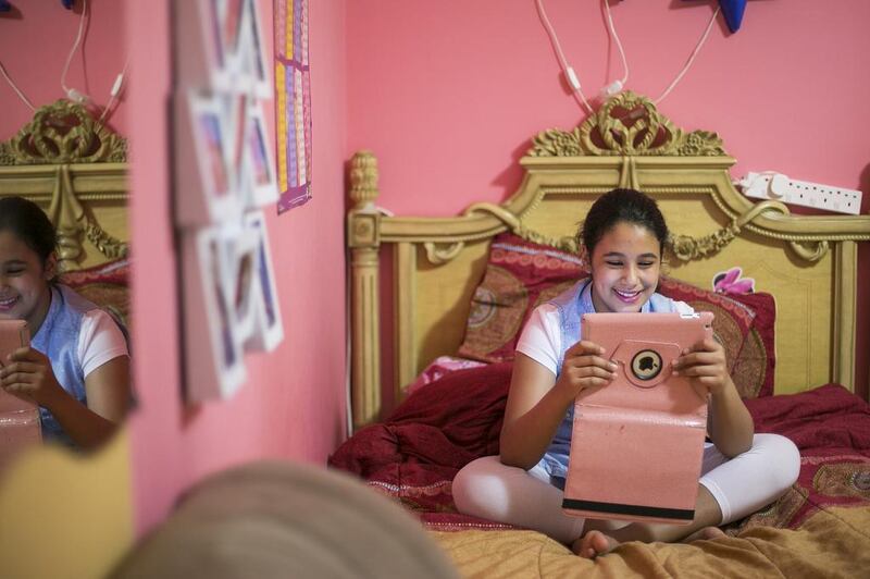Nine-year-old Noora Al Matrooshi plays on her iPad. Mona Al Marzooqi / The National