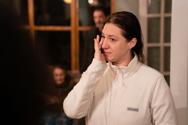 Valeriia Starkova wipes a tear from her eye as she is reunited with her family in Caldecote.