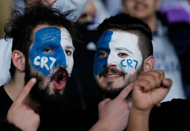 Fans of Real Madrid's Cristiano Ronaldo show their support from the stands. Hassan Ammar / AP Photo