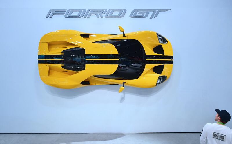 A visitor looks at a Ford GT mounted on a wall at the show. AFP