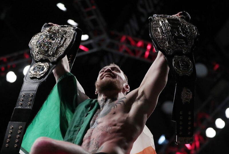 Conor McGregor holds up his title belts after he defeated Eddie Alvarez during a lightweight title mixed martial arts bout at UFC 205, early Sunday, November 13, 2016, at Madison Square Garden in New York. Julio Cortez / AP Photo