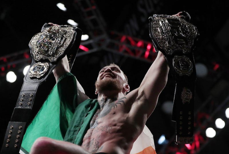 Conor McGregor holds up his title belts after he defeated Eddie Alvarez during a lightweight title bout at UFC 205 on November 13, 2016, at Madison Square Garden in New York.