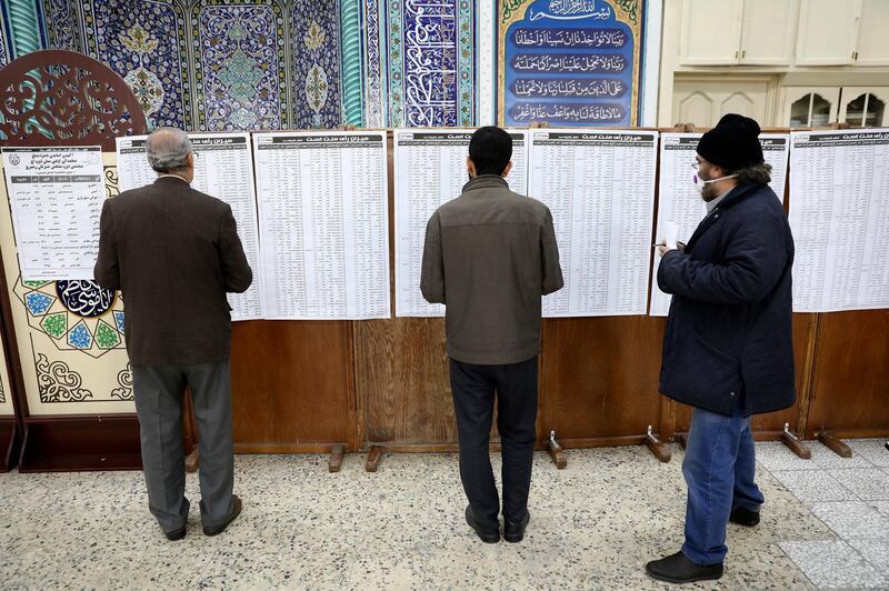 Voters check the lists of candidates in the parliamentary elections at a polling station in Tehran, Iran. AP