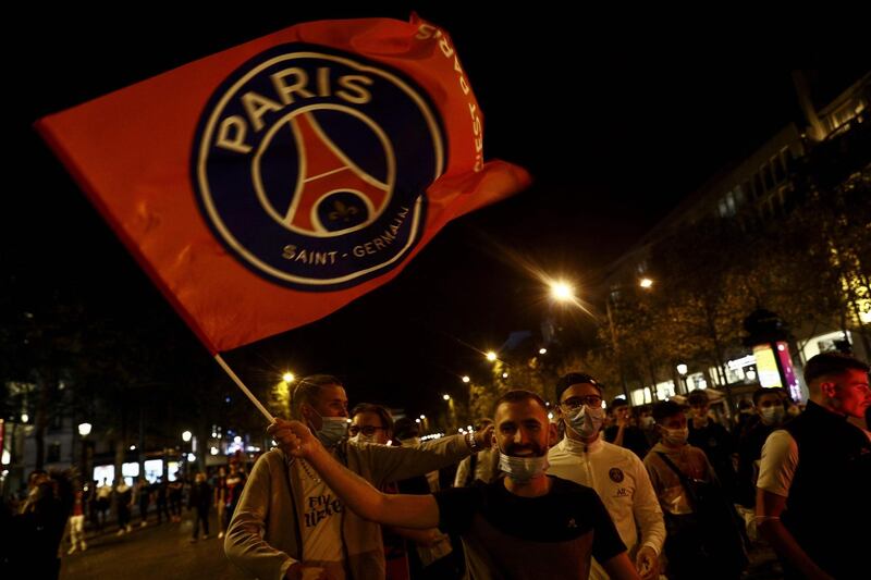 Paris Saint-Germain supporters wave a PSG flag on the Champs-Elysees in Paris. AFP