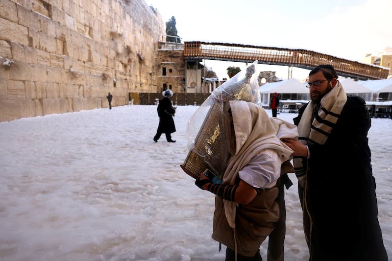 An ultra-Orthodox Jewish man carries a Torah scroll at the Western Wall in Jerusalem. Reuters