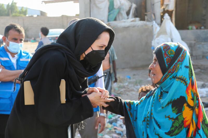 UNHCR special envoy Angelina Jolie shakes hands with a woman displaced by war during a visit to the southern province of Lahej, Yemen March 6, 2022.  REUTERS / Fawaz Salman