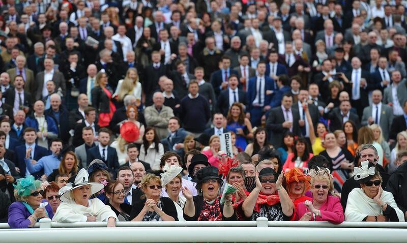 Punters cheer on the riders in the Betford Melling Steeple Chase at Aintree Racecourse on Friday in Liverpool, England. Laurence Griffiths / Getty Images / April 4, 2014  