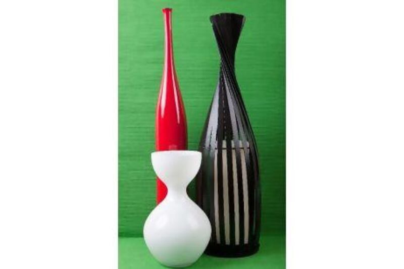Red vase, Dh 329 at ID Design, black candle holder, Dh149 at The One, pillar candle, Dh39 at The One, white vase, Dh75 at @Home, green runner (as background), Dh69 at Zara Home.