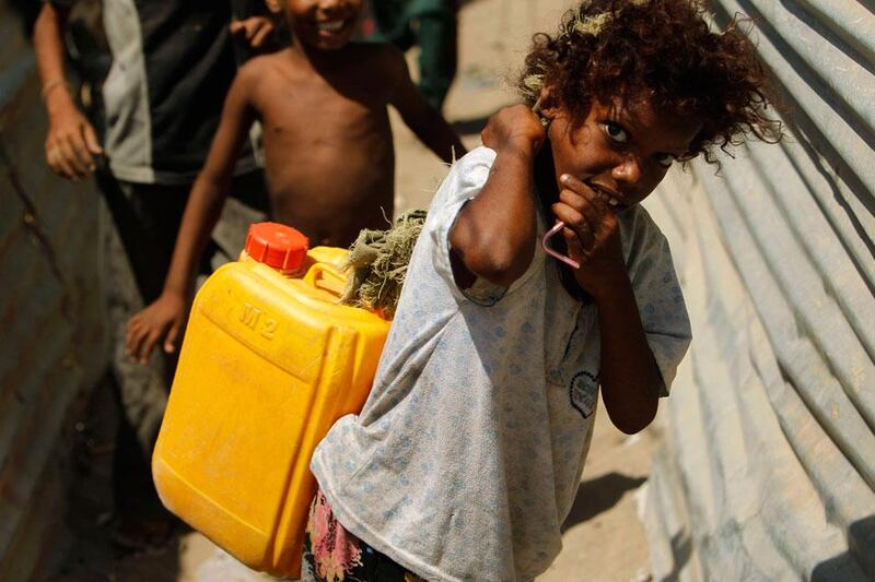 A girl carries a jerry can filled with water she collected from a makeshift well in Houdieda.