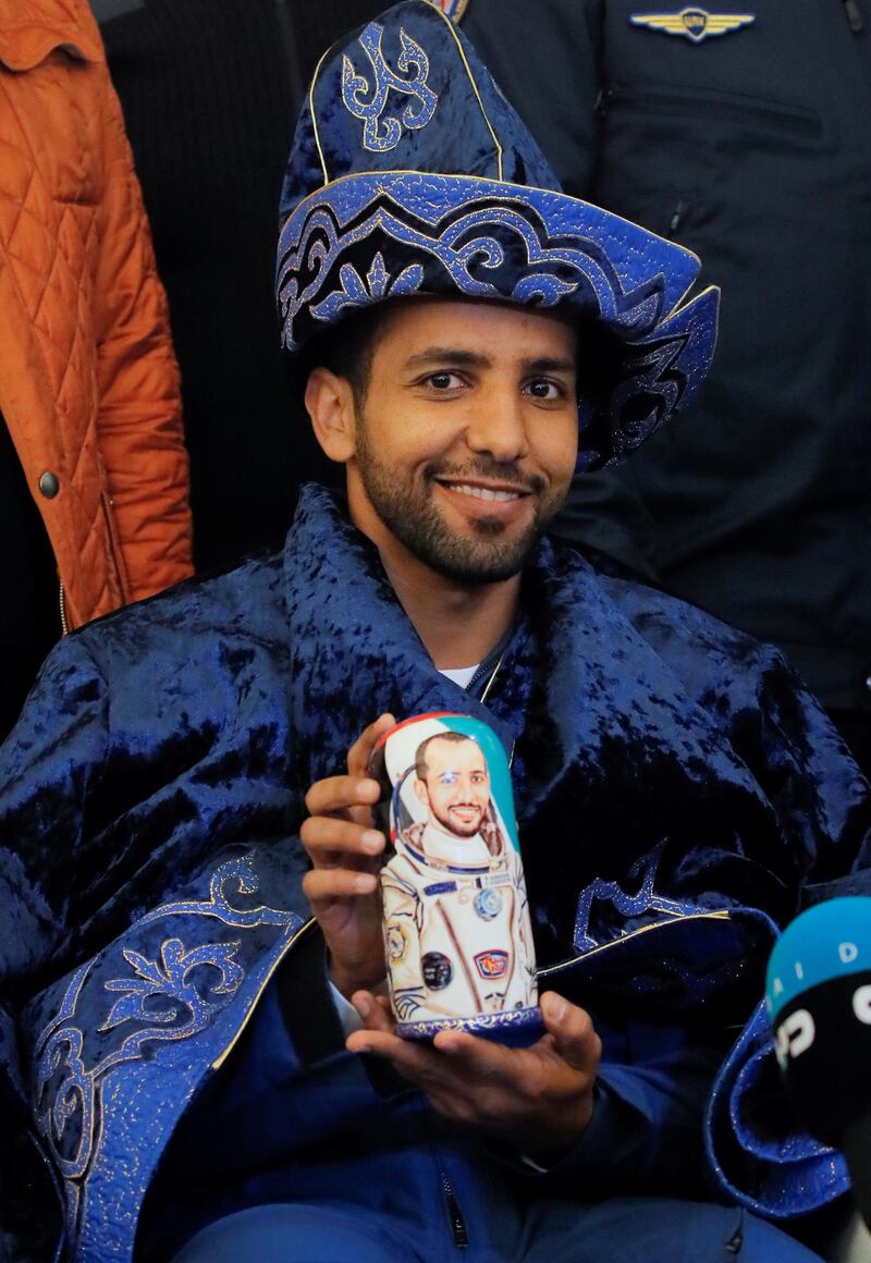 Hazza Al Mansouri poses for a photo wearing a Kazakh national hat and holding a Matryoshka, Russian traditional wooden doll depicting him.  Reuters