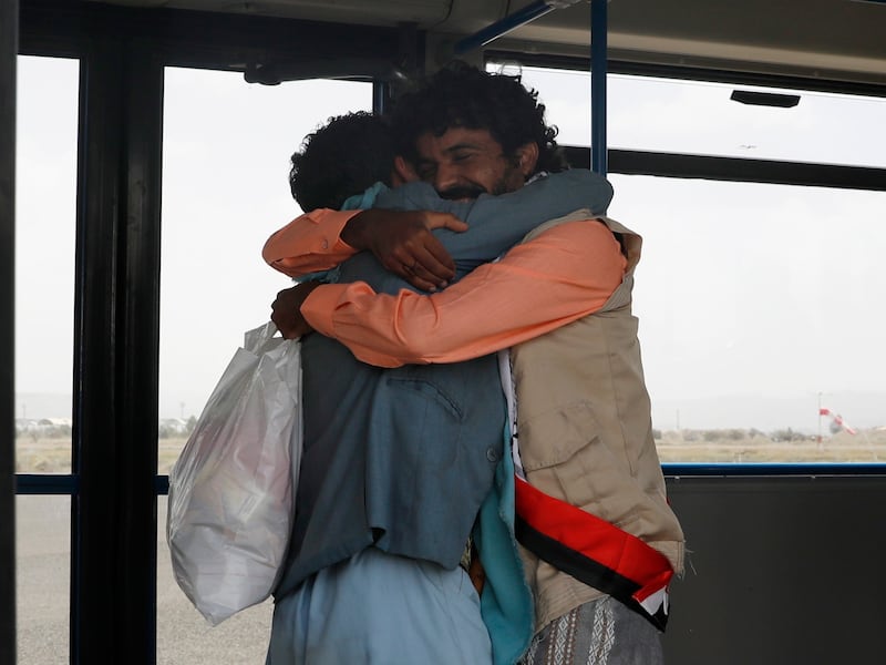 A freed Houthi prisoner, right, greets a relative upon arrival at Sanaa airport in Yemen. EPA