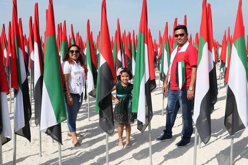 (L-R) Anju Jacob, Evelyn and Sebin Dcruz at the flag garden near Dubai's kite beach on the UAE’s 50th National Day. Pawan Singh / The National