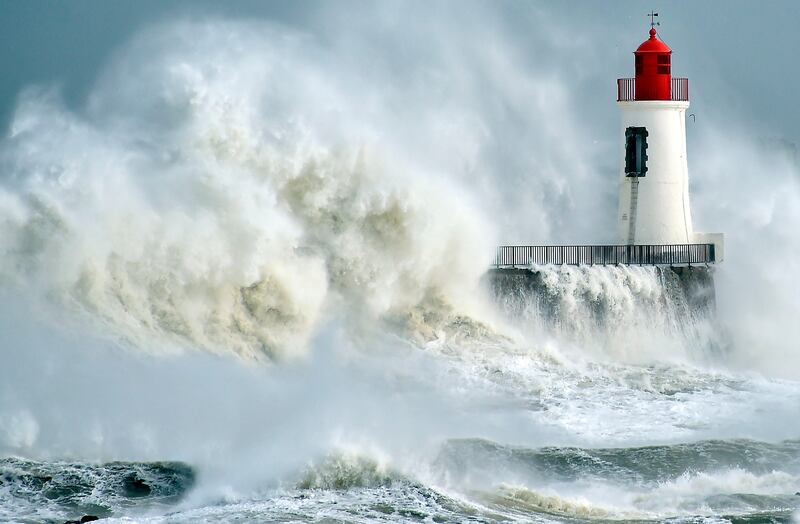 (FILES) This file photo taken on February 9, 2016 shows waves breaking against a pier and a lighthouse in Les Sables-d'Olonne, western France.
Deaths due to weather-related disasters in Europe could increase fifty-fold from an estimated 3,000 per year recently to 152,000 by century's end, mainly due to climate change, researchers warned on August 5, 2017.
 / AFP PHOTO / LOIC VENANCE