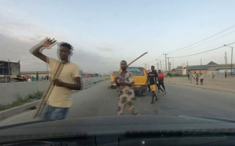 Men carry sticks and block a road in Lagos, Nigeria. Reuters