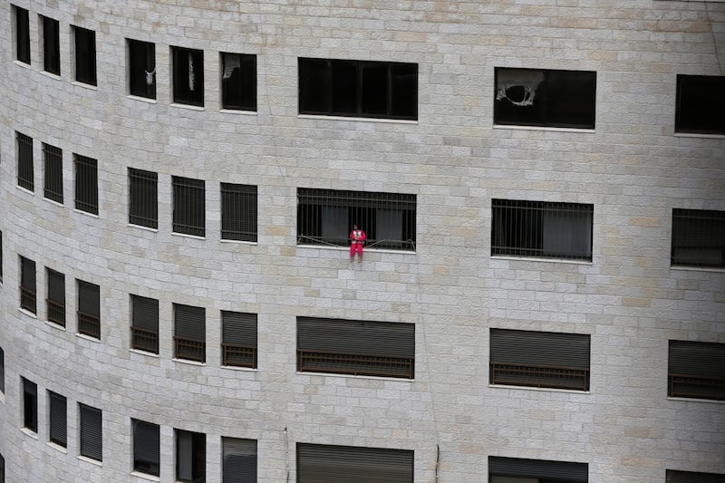 A Palestinian girl sits on the window of a multi-storey building in the West Bank city of Nablus.  EPA