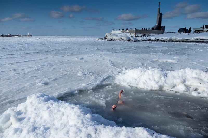 An Orthodox believer takes a bath in an ice hole in a bay of the Pacific Ocean outside the Russian town of Kholmsk. AFP Photo