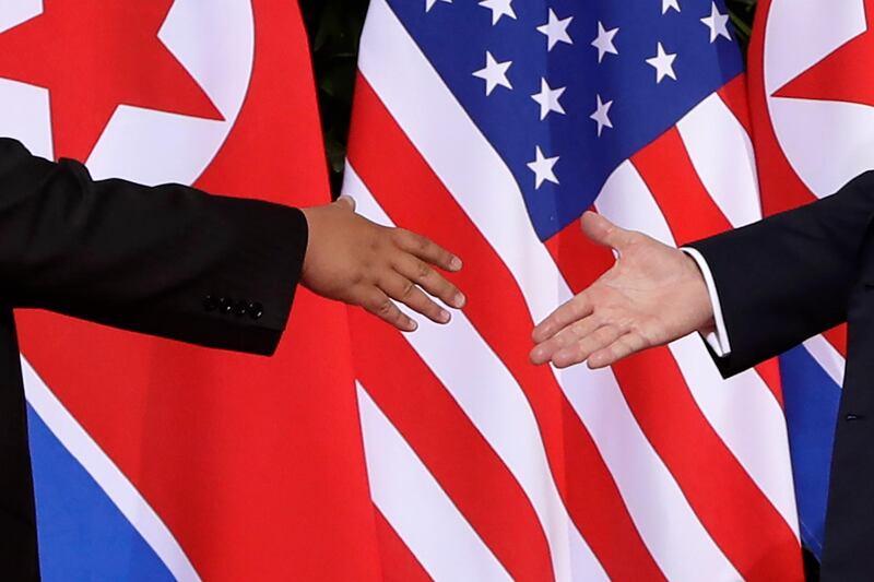 US President Donald Trump, right, reaches to shakes hands with North Korea leader Kim Jong-un. Evan Vucci / AP Photo