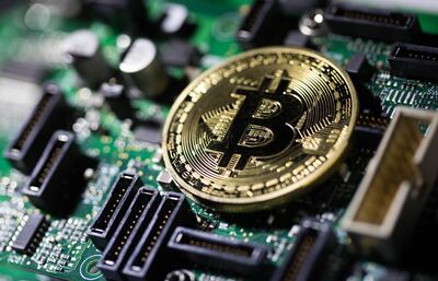 FILE: A coin representing Bitcoin cryptocurrency sits on a computer circuit board in this arranged photograph in London, U.K., on Tuesday, Feb. 6, 2018. The great cryptocurrency crash of 2018 is heading for its worst week yet. Bitcoin sank toward $4,000 and most of its peers tumbled on Friday, extending the Bloomberg Galaxy Crypto Index’s weekly decline to 25 percent. That’s the worst five-day stretch since crypto-mania peaked in early January. Photographer: Chris Ratcliffe/Bloomberg