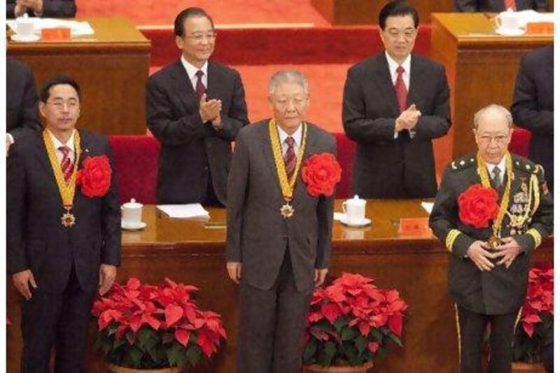 Hu Jintao, president of China, right, and the premier Wen Jiabao award medals at a meeting marking the 90th anniversary since the founding of the Communist Party of China.