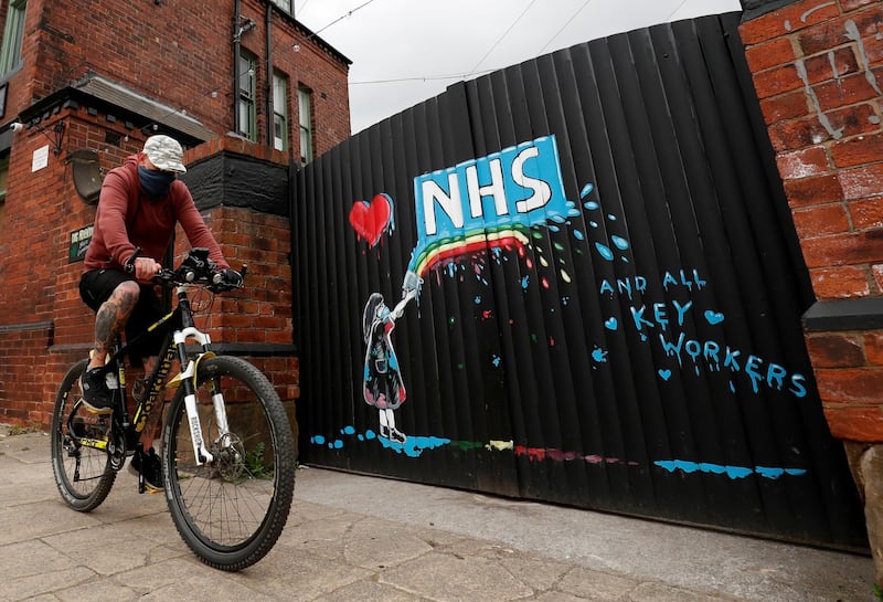 A cyclist rides past a mural in tribute to the NHS painted by artist Rachel List in Pontefract, Britain. Reuters