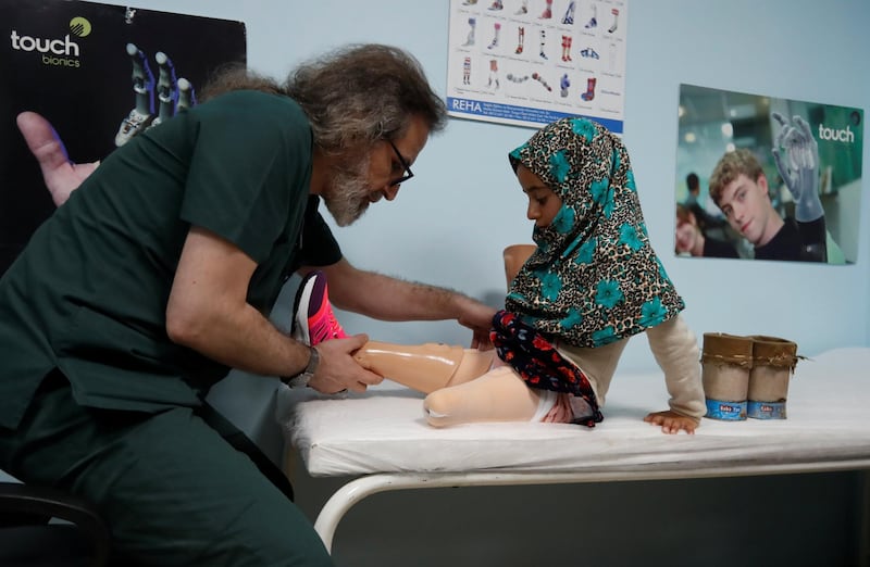 Dr Mehmet Zeki Culcu adjusts Maya's new limbs. Reuters