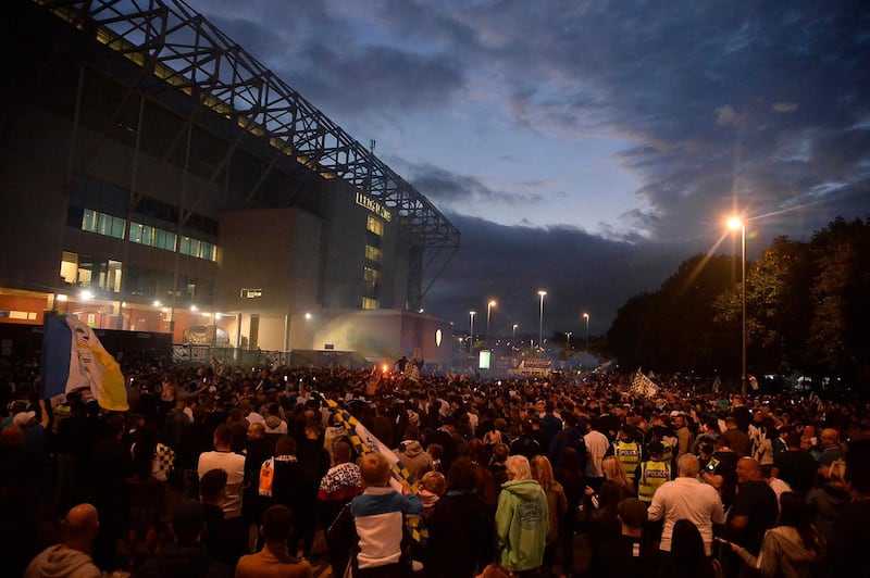 Leeds United players celebrate with fans outside Elland Road. EPA