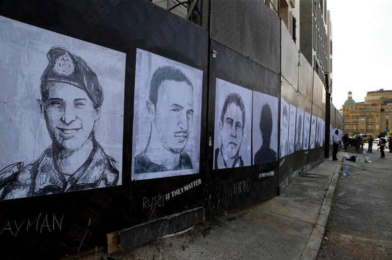 Activists hang portraits of the victims of the August 4 Beirut port explosion on a wall in the Lebanese capital. Artist Brady Black, in partnership with the Art of Change organisation, drew more than 200 caricatures of the victims. EPA