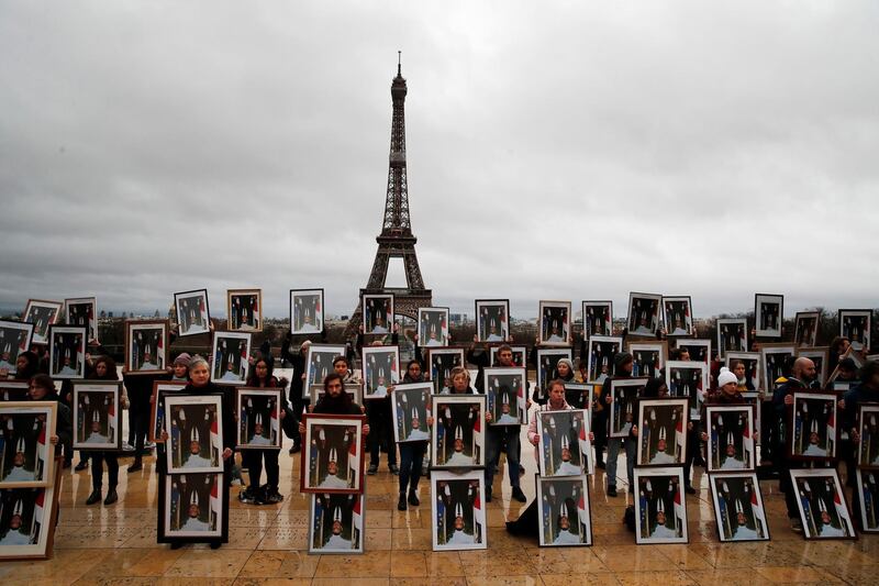 Activists hold portraits of President Emmanuel Macron upside down to urge France to take action during the UN COP 25 climate talks in Madrid, during a gathering at Place du Trocadero facing the Eiffel Tower in Paris. AP Photo