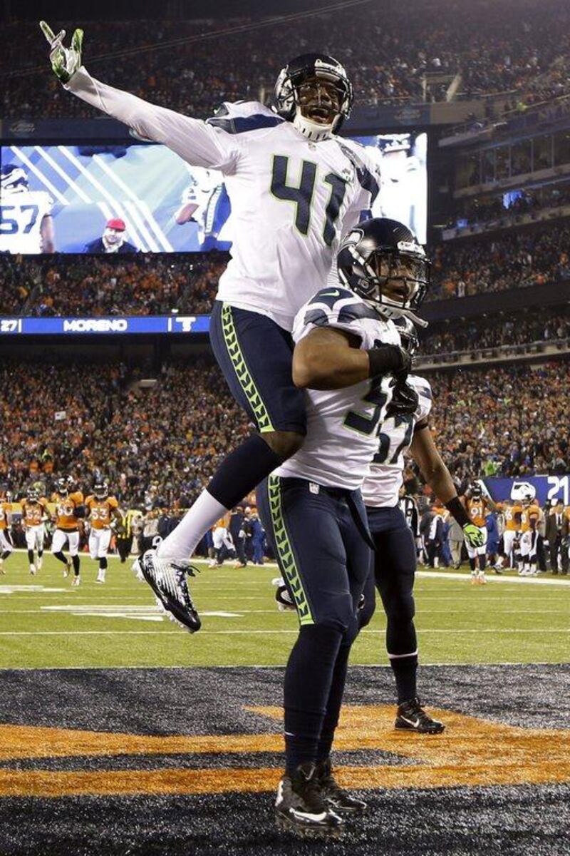 Byron Maxwell, top, celebrates with teammate Malcolm Smith after Smith scored a touchdown on Sunday. Mark Humphrey / AP 