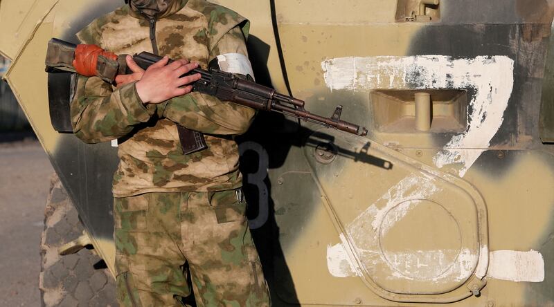 A pro-Russian fighter stands guard next to a combat vehicle, before the evacuation of wounded Ukrainian soldiers from the besieged Azovstal steel mill,in Mariupol. Reuters