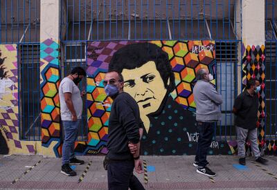 Voters line up in front a mural depicting songwriter Victor Jara in Santiago. AP