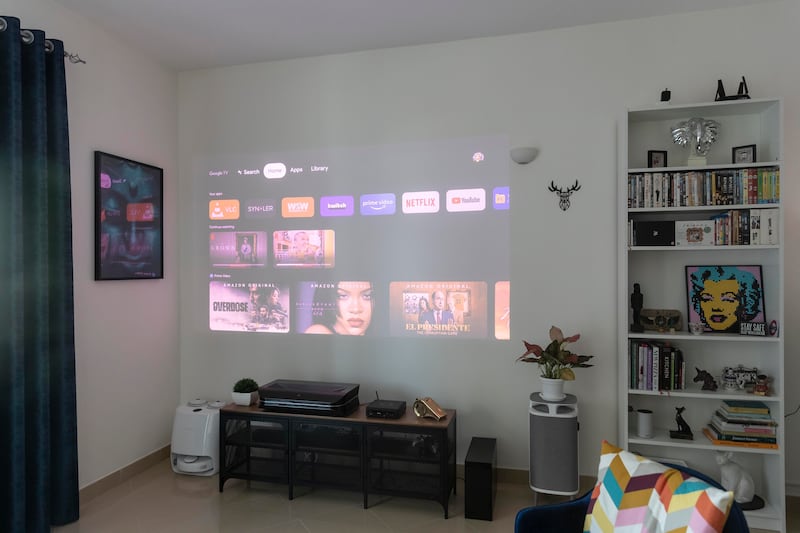 A projector beams movies and programmes on the wall with an image size of about 100 inches.
