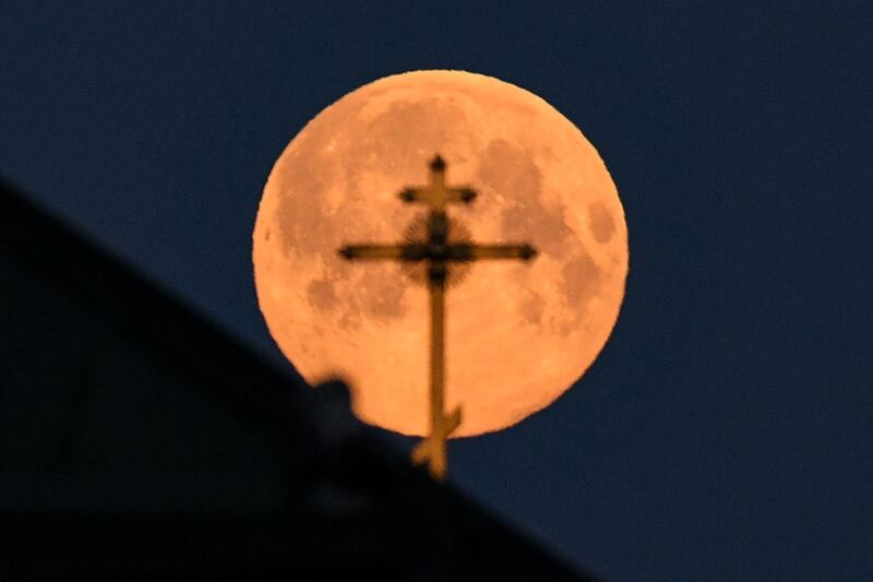 The church cross is silhouetted by the pink supermoon in downtown Moscow, Russia. AFP
