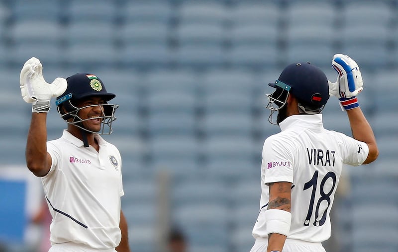 India's Mayank Agarwal, left, celebrates scoring a century with captain Virat Kohli during the second cricket test match between India and South Africa in Pune, India, Thursday, Oct. 10, 2019. (AP Photo/Rajanish Kakade)