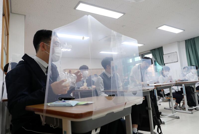 Pupils sit behind protective shields as a preventative measure against the coronavirus in a classroom in Daejeon, South Korea. AFP