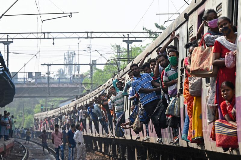 Commuters watch after their train was blocked by activists at a railway station in Kolkata. AFP