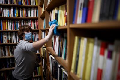 MADRID, SPAIN - MAY 04: Elena Banaseanu cleans and disinfects the books of the Antonio Machado bookstore on the first day of attention to the public after 51 days of closure due to the COVID 19 coronavirus  on May 04, 2020 in Madrid, Spain. Spain is opening new businesses as hairdressers, delivery food restaurants and book shops after weeks of lockdown. Spain has had more than 218,000 confirmed cases of COVID-19 and over 25,000 reported deaths, although the rate has declined after weeks of lockdown measures. (Photo by Carlos Alvarez/Getty Images)