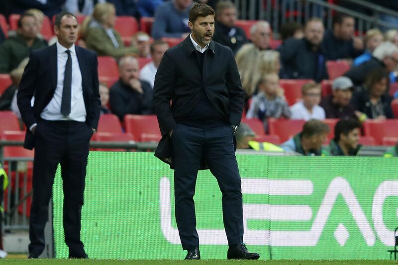 Tottenham manager Mauricio Pochettino, right, and Swansea manager Paul Clement, left, looks across the pitch during the English Premier League soccer match between Tottenham Hotspur and Swansea City at Wembley stadium in London, Saturday Sept. 16, 2017. (AP Photo/Tim Ireland)