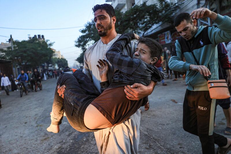Palestinians help a boy injured in an Israeli strike in Rafah. AFP