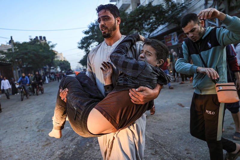 Palestinians help a boy injured in an Israeli strike in Rafah. AFP