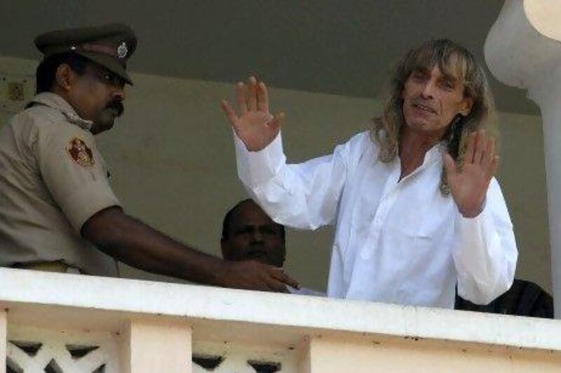 Paolo Bosusco, an Italian tour guide who was taken hostage by Maoist rebels, waves from a balcony of a guesthouse after being freed by rebels in the eastern Indian city of Bhubaneswar.